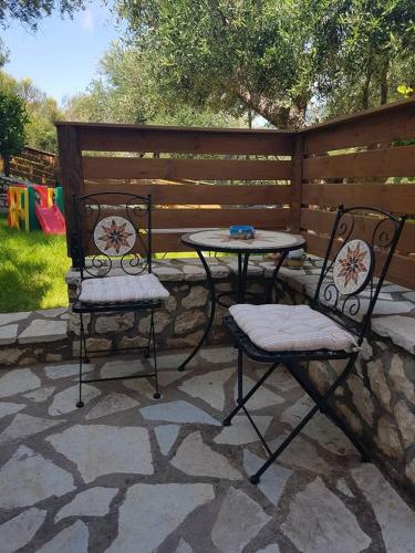 two chairs and a table on a stone patio at Rania Apartments in Agios Nikitas