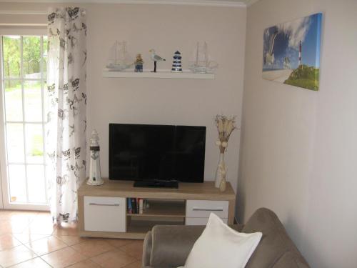 a living room with a flat screen tv on a stand at Strandvilla Kalifornien direkt am Meer in Kalifornien