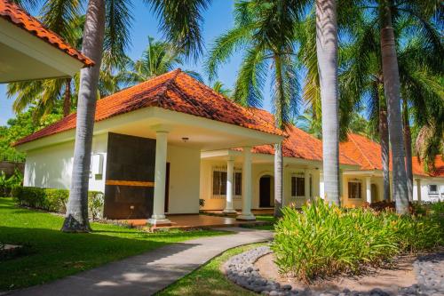 una casa con tetto arancione e palme di Pato Canales Hotel & Resort a San Luis