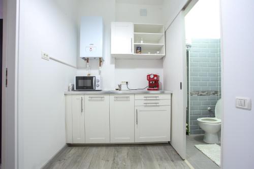 a kitchen with white cabinets and a red appliance at Simona Maria in Bucharest