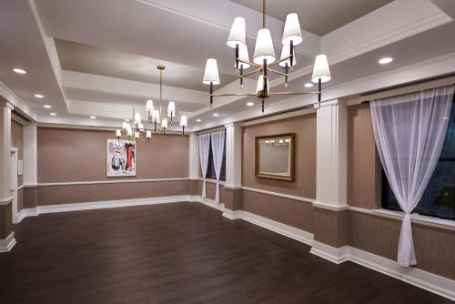 a large room with a chandelier and a hallway at Claridge House in Chicago