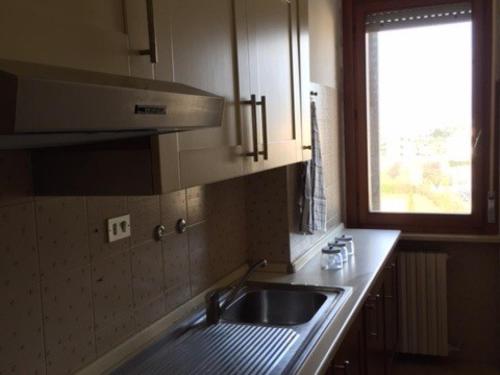 une cuisine avec un évier et une fenêtre dans l'établissement Casa vacanze a pochi metri dal mare, à Grottammare
