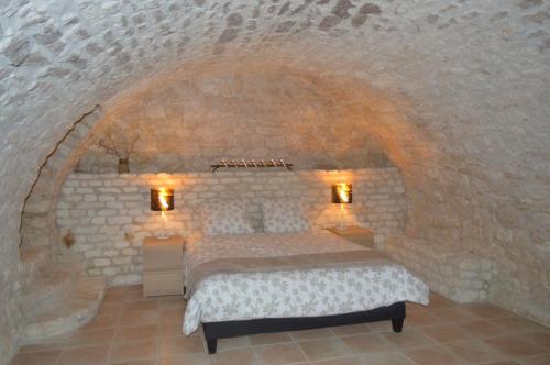 a bedroom with a bed in a stone wall at Gîte Manoir in Bouloc