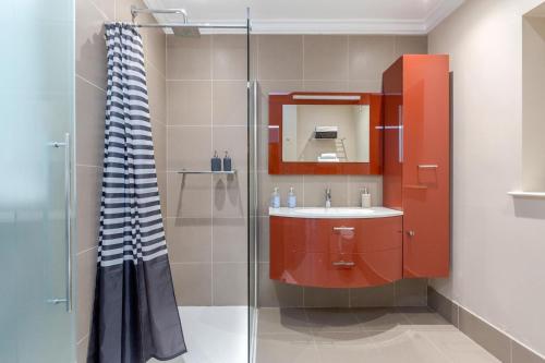 a bathroom with a sink and a glass shower at Luxurious Central Kensington Apartment in London