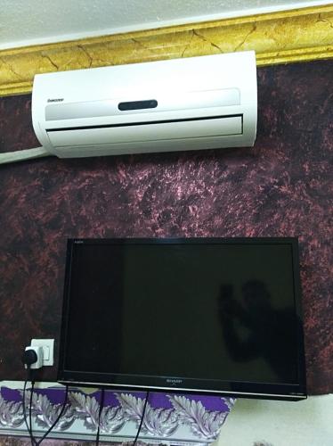 a computer monitor and a air conditioner on a wall at Aqaba Roza in Aqaba
