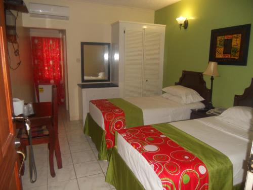 a hotel room with two beds and a mirror at Seaview Inn in Basse Terre Town