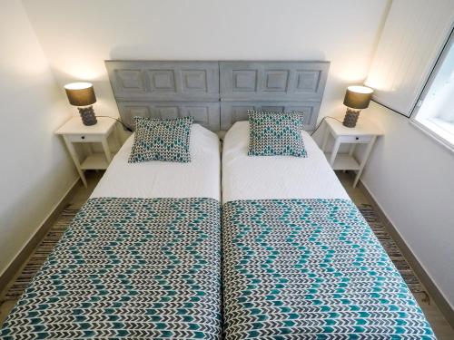 2 camas en un dormitorio con 2 lámparas en las mesas en Casas Burnay I, en Ericeira