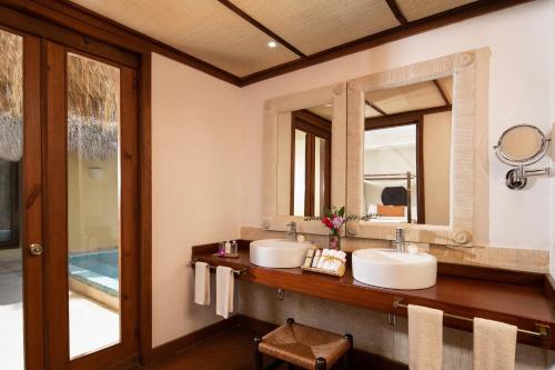 a bathroom with two sinks and two mirrors at Zoetry Agua Punta Cana - All Inclusive in Punta Cana