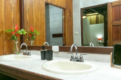 a bathroom with two sinks and a large mirror at La Kukula Lodge in Puerto Viejo