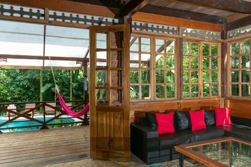 a living room with a couch and a hammock at La Kukula Lodge in Puerto Viejo