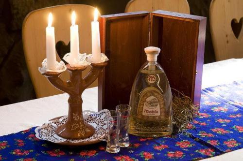 a bottle of whiskey and two candles on a table at Skalny Dworek in Nowy Targ
