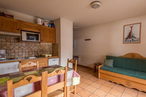 una cucina con tavolo e sedie in una stanza di appartement T2 LES HOUCHES Pied des Pistes a Les Houches