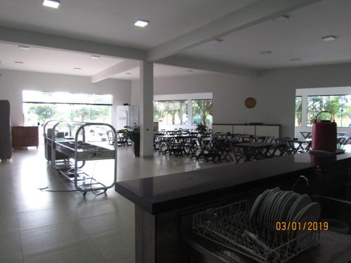 un comedor con mesas, sillas y ventanas en Hotel 7, en Três Lagoas