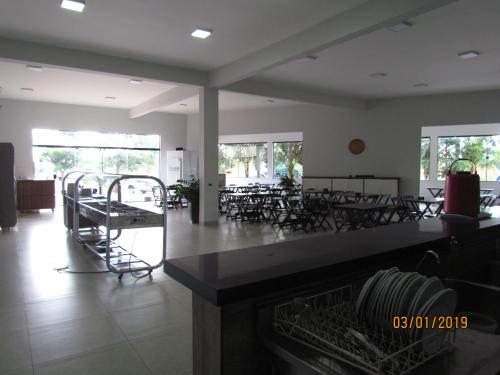 a dining room with tables and chairs and windows at Hotel 7 in Três Lagoas