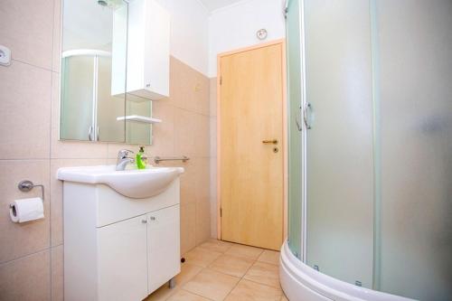 a bathroom with a sink and a glass shower at Apartment Varezic in Ston