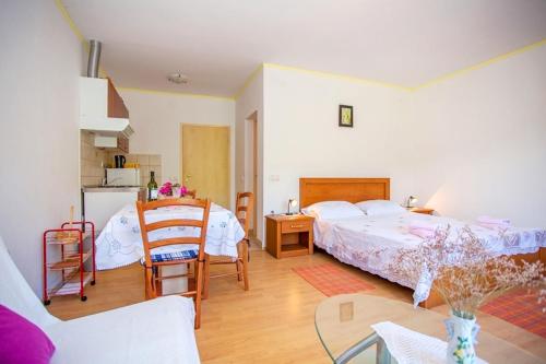 a bedroom with a bed and a table and a kitchen at Apartment Varezic in Ston