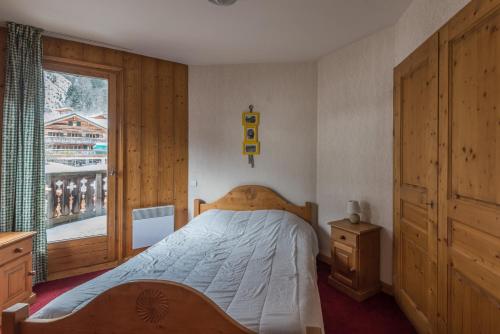 Schlafzimmer mit einem Bett und einem Fenster in der Unterkunft appartement T2 LES HOUCHES Pied des Pistes in Les Houches