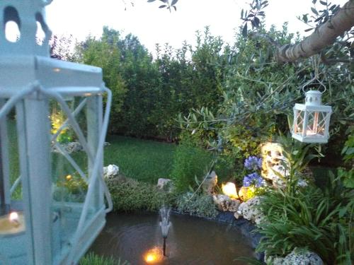 a garden with a pond with a lantern and a fountain at Villetta Dote in Casarano