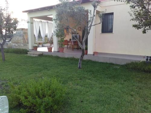 a house with a yard with a table and chairs at Villetta Dote in Casarano