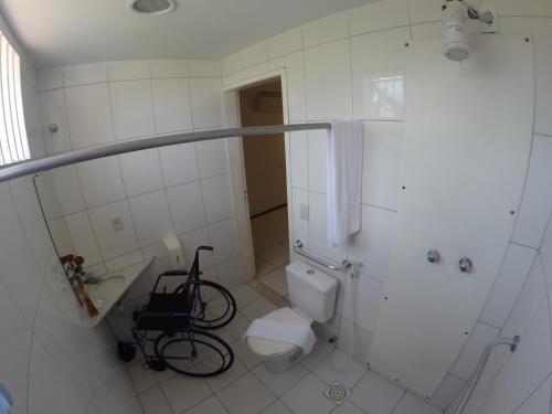 a bathroom with a toilet and a bike in it at Hotel Meridional in Fortaleza