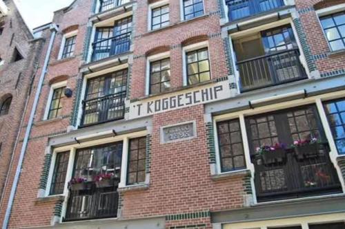 un edificio de ladrillo con ventanas y balcones. en Studio Koggeschip en Ámsterdam