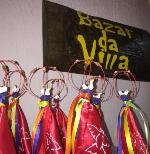 a group of four colorful bags hanging from hooks at Pousada Villa Parahytinga in São Luiz do Paraitinga