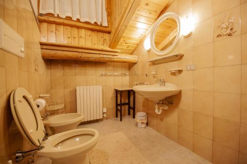 uma casa de banho com um WC e um lavatório em Giacomino Apartment em Livigno