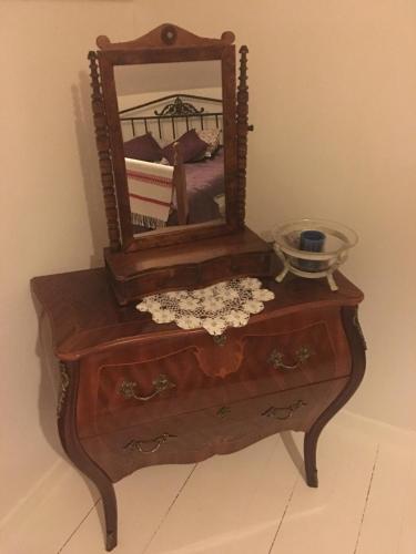 a wooden dresser with a mirror on top of it at Kolstigenhus in Fågelfors
