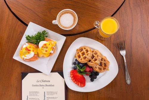 a table with two plates of breakfast foods and a cup of coffee at Ayres Hotel Costa Mesa Newport Beach in Costa Mesa
