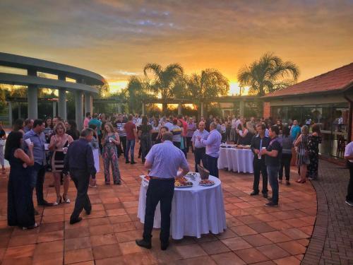 a group of people standing around tables in a crowd at Tenondé Park Hotel in São Miguel das Missões