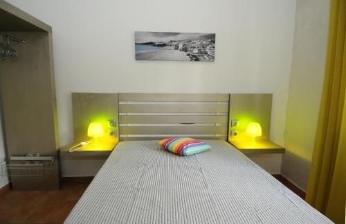 a bedroom with a large bed with two lights on it at Rossio in Albufeira