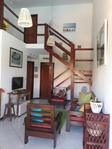 a living room with a spiral staircase in a house at Village Acapulco - Itacimirim/BA in Itacimirim