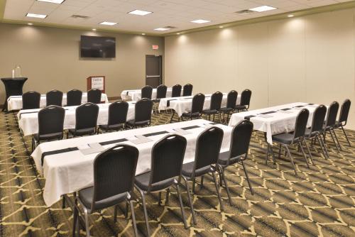 a conference room with white tables and black chairs at Cottonwood Inn and Conference Center in South Sioux City