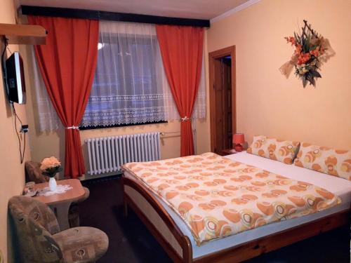 1 dormitorio con 1 cama y una ventana con cortinas rojas en Penzion u Šimona, en Vernár
