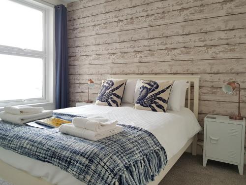 Un dormitorio con una cama y una pared de madera. en Saltwater, en St Ives