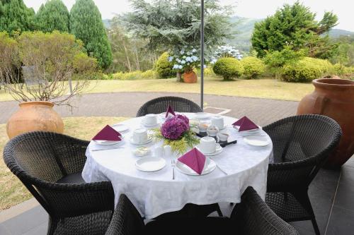 a table with a white table cloth and flowers on it at Quinta Da Cova Do Milho in Santo António da Serra