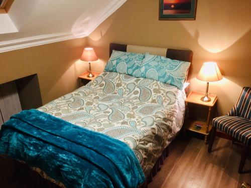 a bedroom with a bed and two lamps and a chair at Pisgah Guesthouse Snowdonia in Blaenau-Ffestiniog
