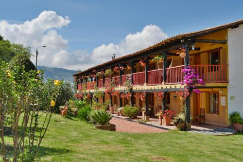 een gebouw met bloemen aan de zijkant bij Hotel Spa Casa de Adobe Villa de Leyva in Villa de Leyva