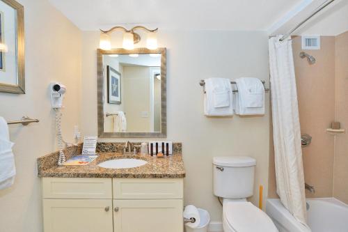 a bathroom with a sink and a toilet and a mirror at Hollywood Beach Tower by Capital Vacations in Hollywood
