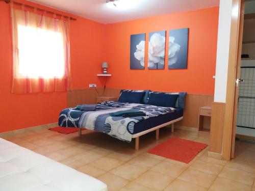 a bedroom with orange walls and a bed in it at Casa Gabriel in Picassent