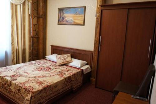 シチョルコヴォにあるЩелковый путьのベッドルーム1室(ベッド1台、キャビネット、写真付)