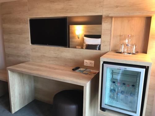 a bar in a hotel room with a tv and a drink cooler at Villa Aruba & Private SPA Suites in Keszthely