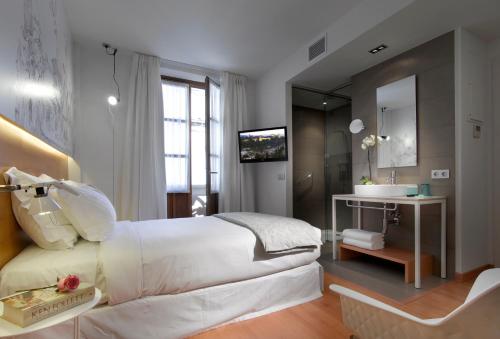 a bedroom with a large white bed and a sink at Hotel Párraga Siete in Granada