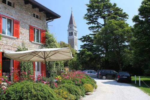 a building with an umbrella and a clock tower at Delparco Hotel in Buttrio