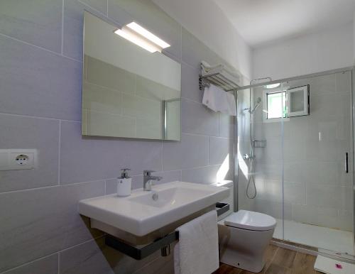 a bathroom with a sink and a toilet and a mirror at Bungalows del Lago - Astbury Formentera in La Savina