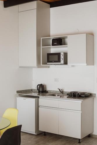 una cucina bianca con mobili bianchi e un forno a microonde di Casa Nuestra a Córdoba