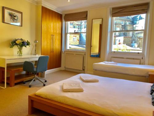 ロンドンにあるBuckingham Palace View Apartmentのベッド、デスク、デスクが備わる客室です。