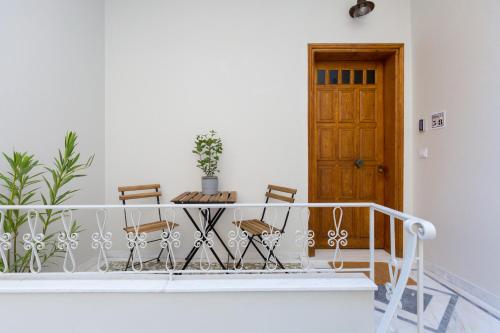 a table and chairs on a balcony with a door at Dinostratus House in Athens