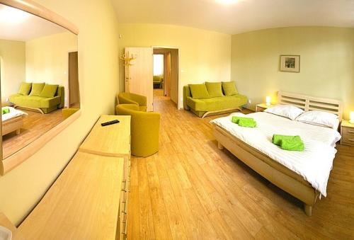 a bedroom with a bed and a living room at Penzion U Bohuša in Lednice