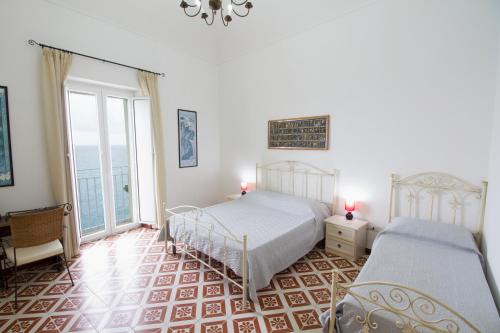 una camera con due letti e una grande finestra di Isola Bella Sea-view Apartment a Tropea